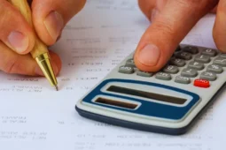 Presupuesto mensual ingresos bajos con persona calculando gastos y revisando facturas del hogar.