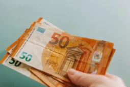 Billetes junto a contenido sobre microcréditos en España.