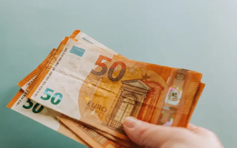 Billetes junto a contenido sobre microcréditos en España.