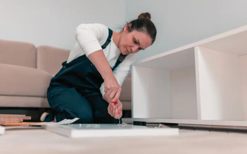 Familia sentada en la mesa del comedor reparando ropa y pequeños electrodomésticos, en una muestra clara de economía circular doméstica.